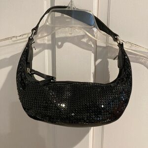 Small black bag used for evening wear. Maybe beaded. Don’t know what it is.